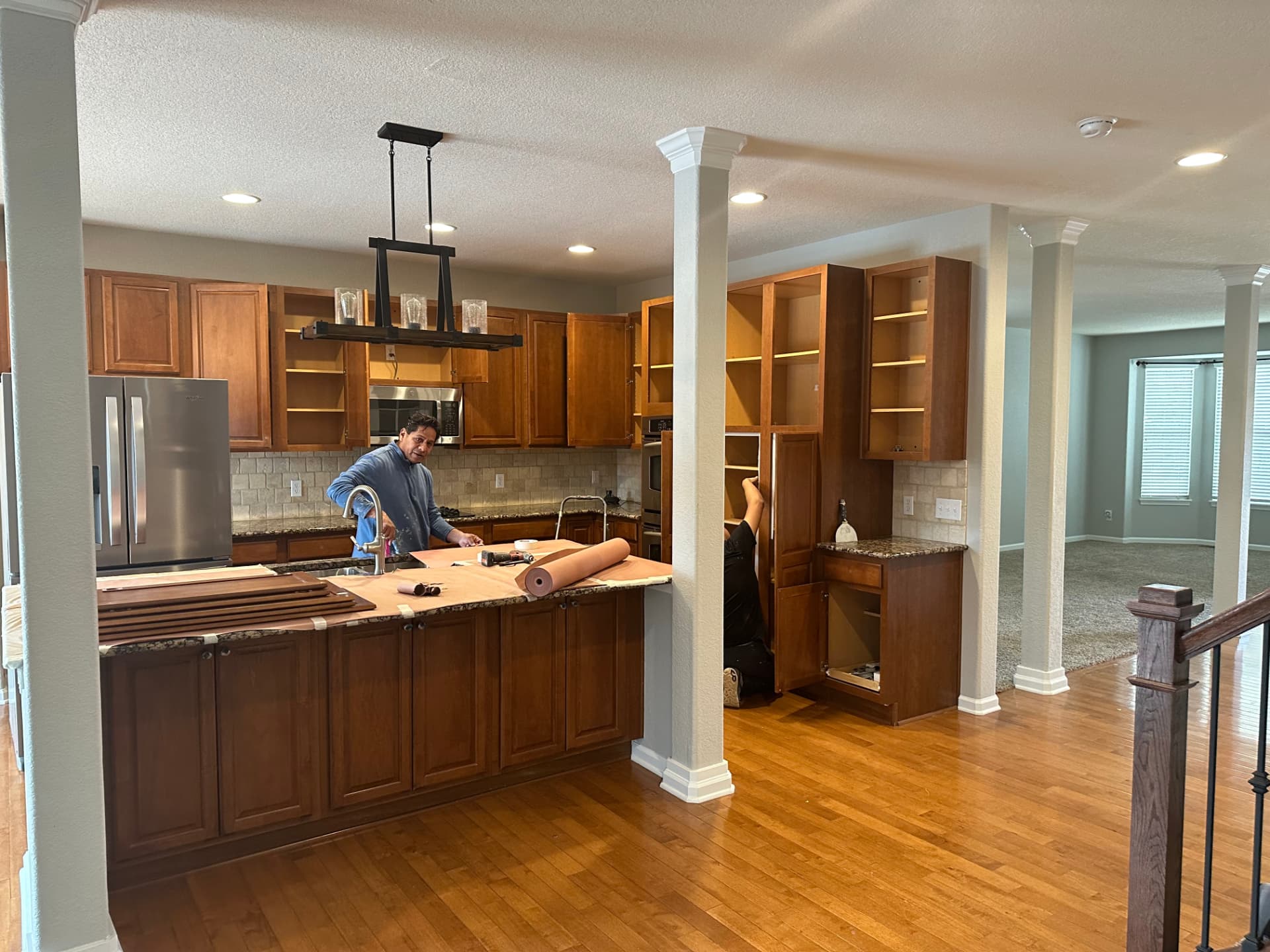 Kitchen with original oak cabinets masked and prepared for professional cabinet painting